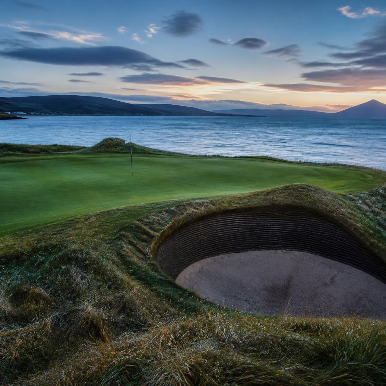 Revetted bunker and green beside the Moray Firth at dusk
